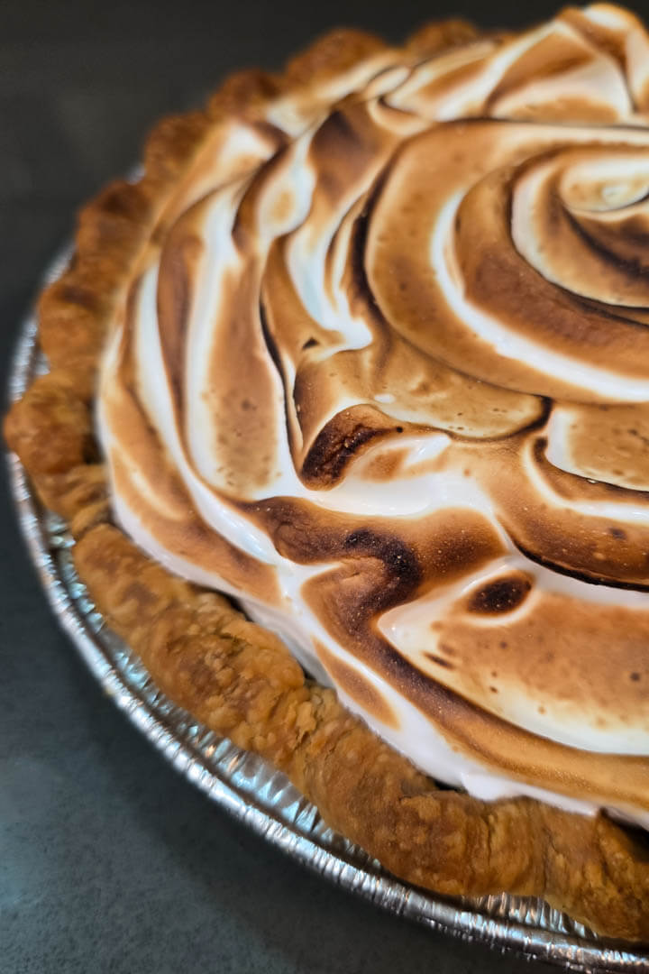 grapefruit meringue pie closeup photo with a toasted meringue topping spread in a crimped flaky pie crust