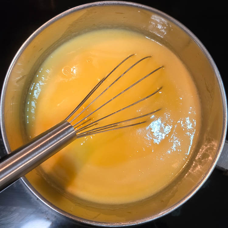 grapefruit curd being cooked on a stovetop