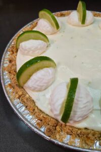 Frozen Margarita Pie close up photo in a pretzel crust decorated with whipped cream and lime slices