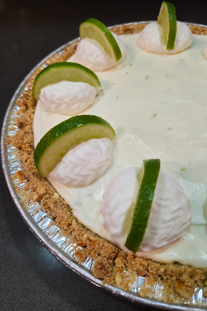 Frozen Margarita Pie close up photo in a pretzel crust decorated with whipped cream and lime slices
