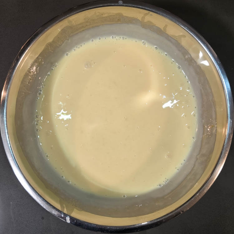pink grapefruit pie filling mixed in a metal mixing bowl