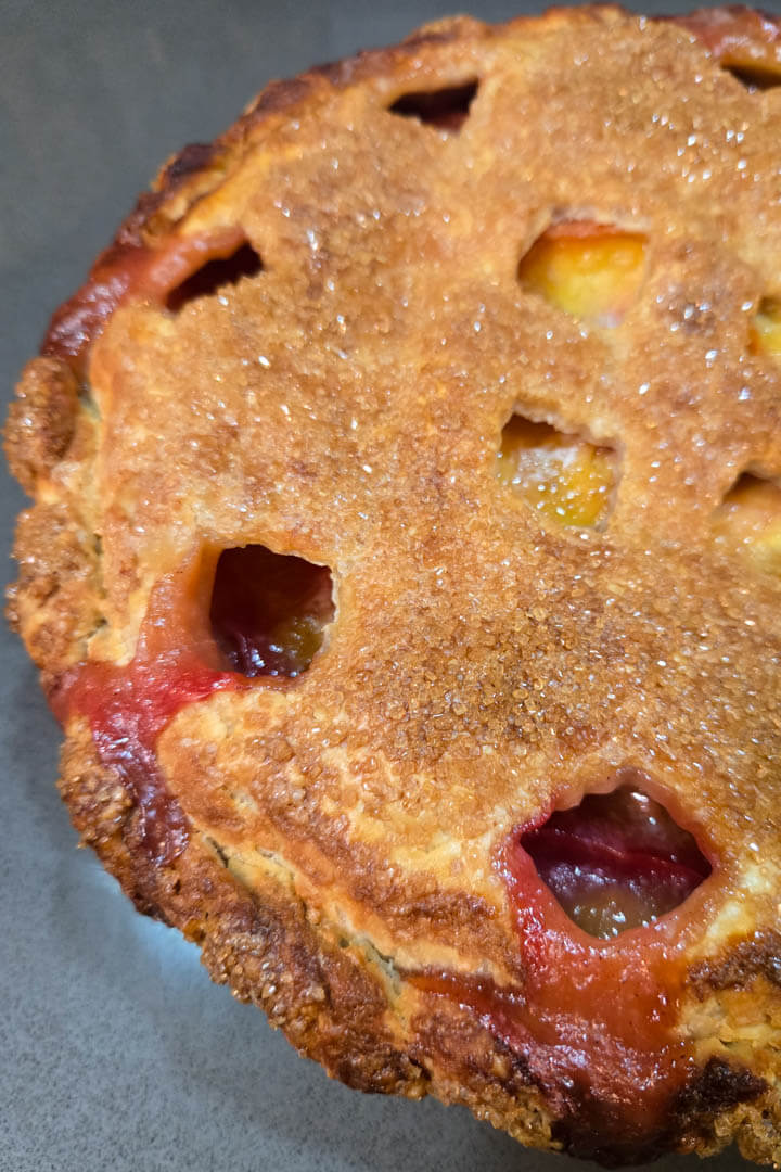 close up photo of a double crusted peach pie with diamond cut outs