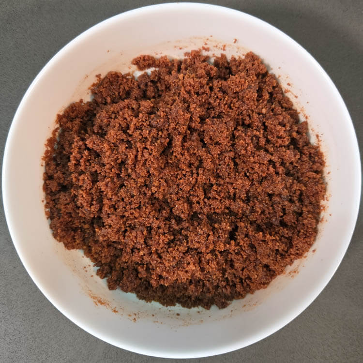 mixing together speculoos pie crust in a white bowl