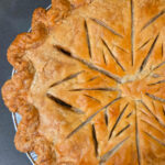 Golden baked turkey pot pie with a decorative scored top crust and crimped edges, overhead view