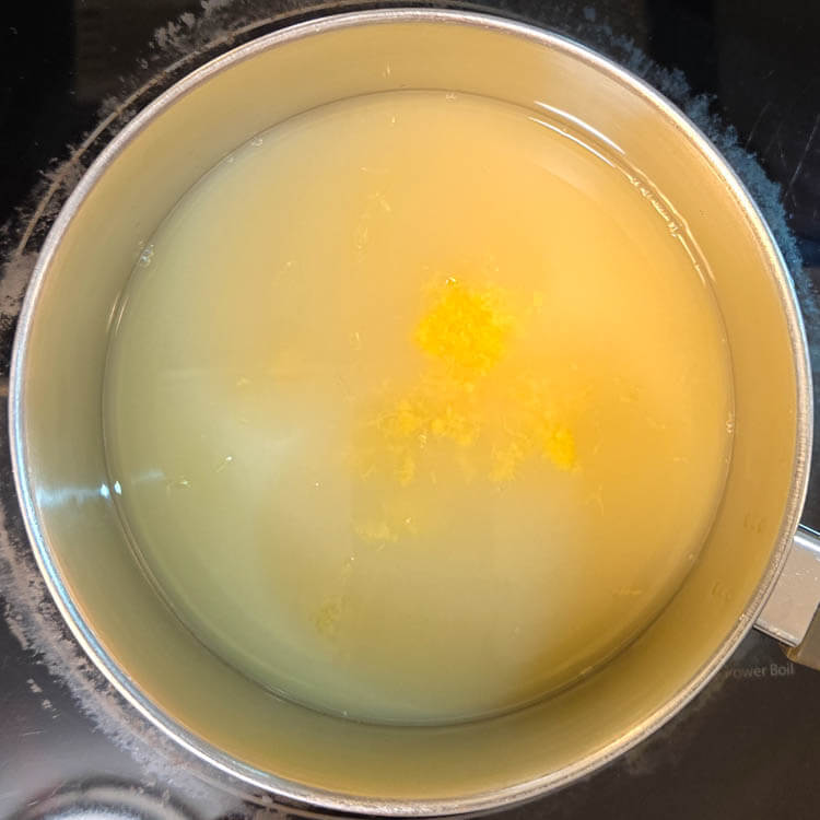 lemon juice, lemon zest, and sugar being heated on the stovetop