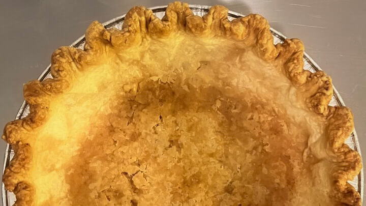 half of a fully blind baked pie crust with crimped edges